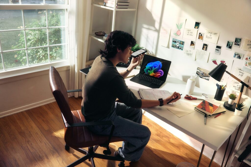 Person working at a desk with a laptop and books. top edtech
