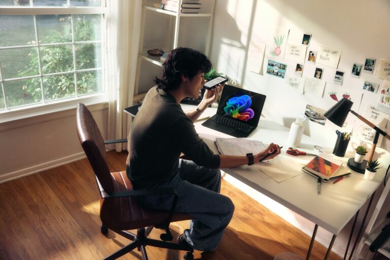 Person working at a desk with a laptop and books. top edtech